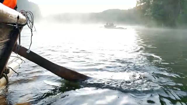 近距离观看木船划桨在竹筏通过雾漂浮在湖面上在早上在庞ung, Mae Hong Son，泰国视频素材