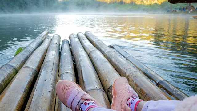 小女孩的特写脚在竹筏上通过雾漂浮在湖面上在早上在庞ung, Mae Hong Son，泰国视频素材