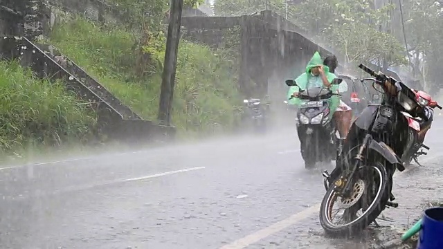 下雨期间，印尼巴厘岛的典型街道上交通繁忙视频素材