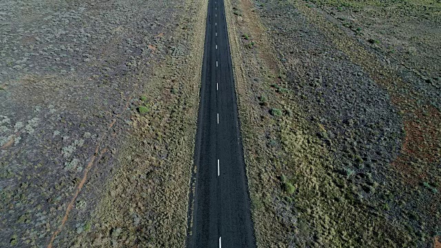 4k空中汽车在沙漠黑色道路上行驶视频素材