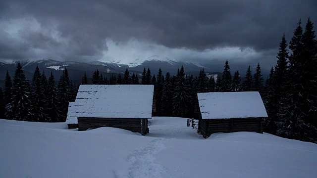 时间流逝雷云移动在冬天山脉房子小屋小屋黑暗的松树森林前景自然景观漫游视频素材