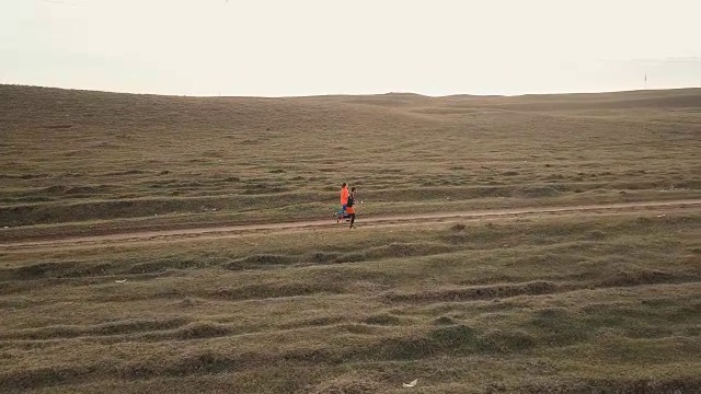 空中拍摄的女人和男人在绿色的周围奔跑视频素材