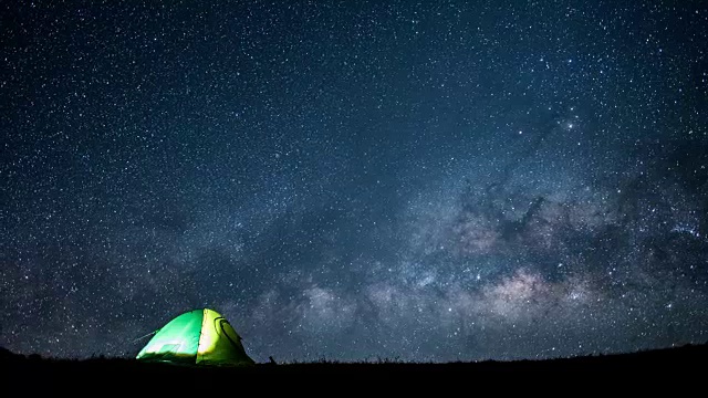 银河的时间流逝和星星与银河在天空的夜晚时间与帐篷露营在山上视频素材