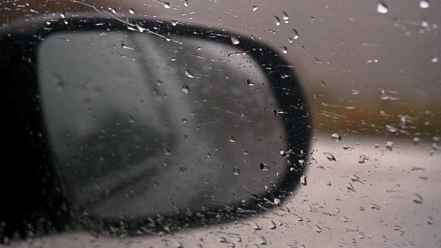 在雨中开车从车内看，看到汽车的后视镜视频素材