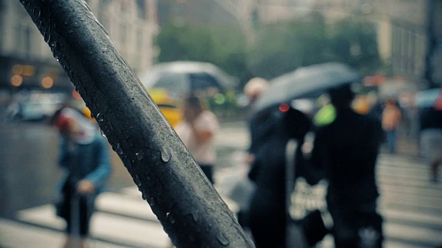 慢镜头下的行人撑着雨伞在曼哈顿下雨的街道上视频素材