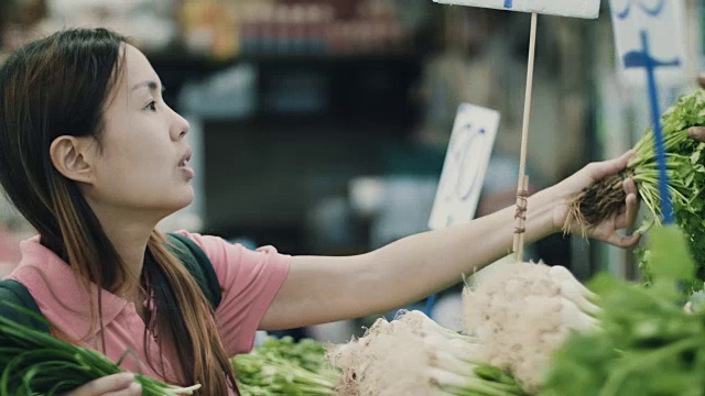 年轻女子在超市的菜区挑选蔬菜视频素材