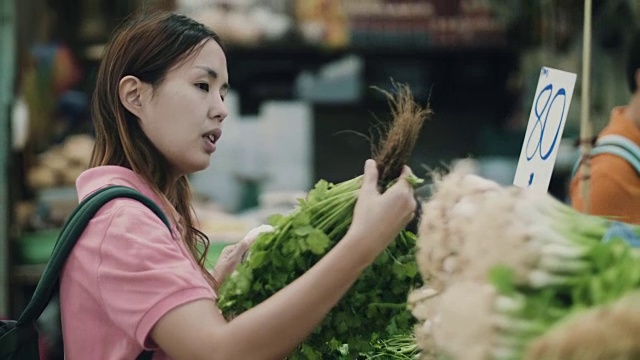 年轻女子在超市的菜区挑选蔬菜视频素材