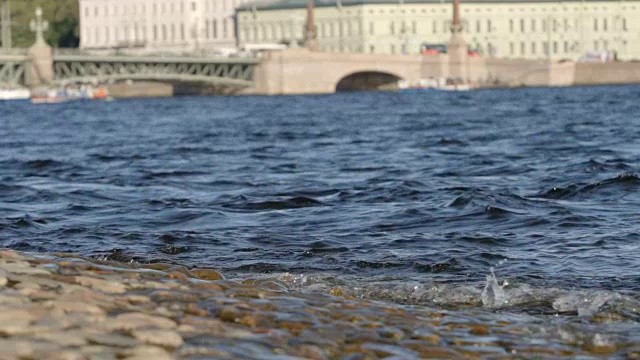 慢镜头:在夏季的俄罗斯圣彼得堡，涅瓦河在三一桥上的波浪背景视频素材