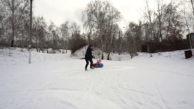 妈妈宝宝在雪橇上滚动视频下载