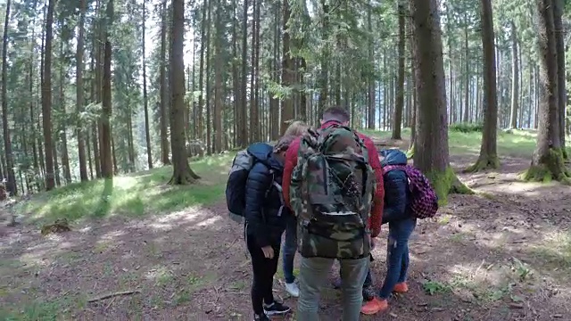 青少年朋友旅行者看地图计划通过森林徒步旅行和冒险的森林概念视频素材