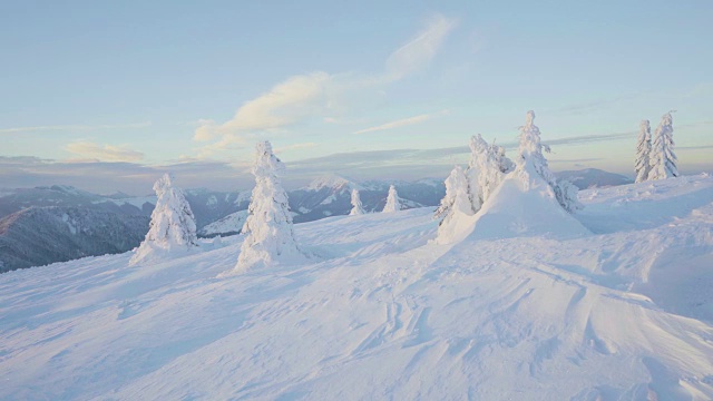 冬季日落时，冰雪覆盖的景观和山上的树木视频素材