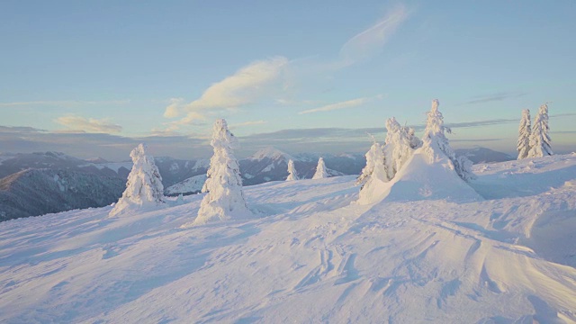 冬季日落时，冰雪覆盖的景观和山上的树木视频素材