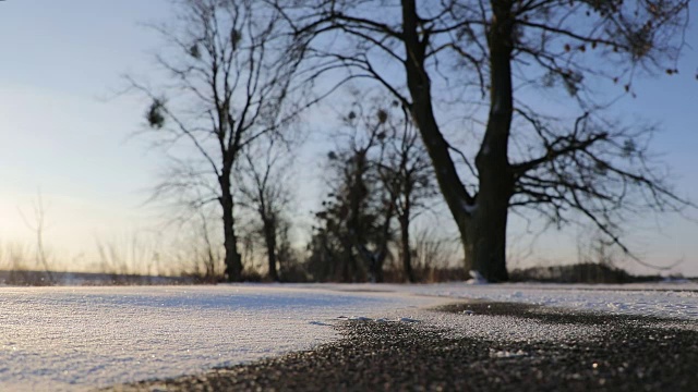 清晨，风和雪在一条荒芜的道路上视频素材