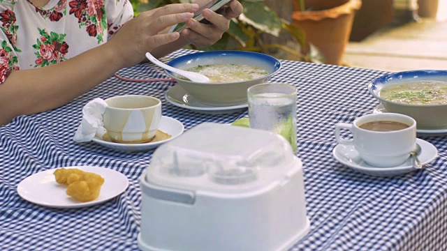 一边吃早餐一边玩手机的女人视频素材