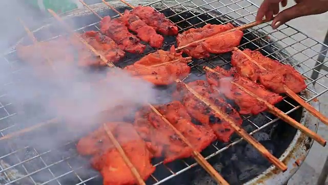 泰国街头小吃，沙爹猪肉，烧烤炸猪肉条，泰国市场视频素材