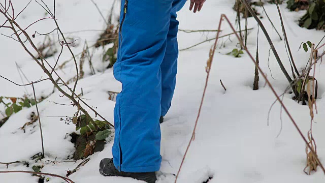 森林里的男孩。雪地里的脚步声。蓝色裤子，棕色头发。害怕和孤独视频素材