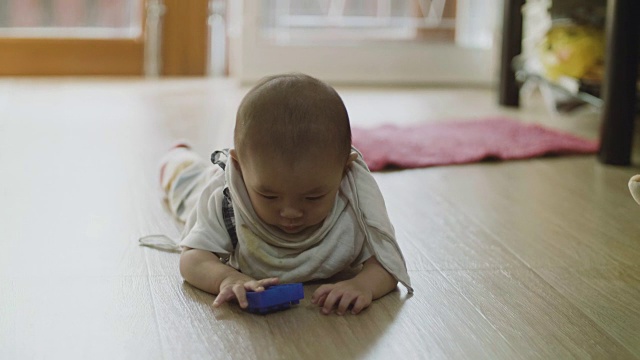 快乐的小男孩在地板上玩视频素材