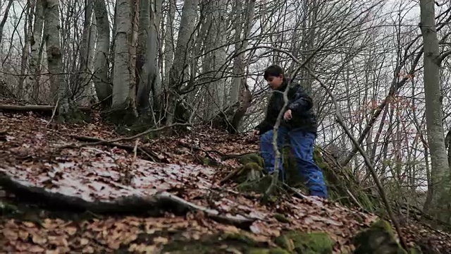 森林里的男孩。雪地里的脚步声。蓝色裤子，棕色头发。害怕和孤独视频素材