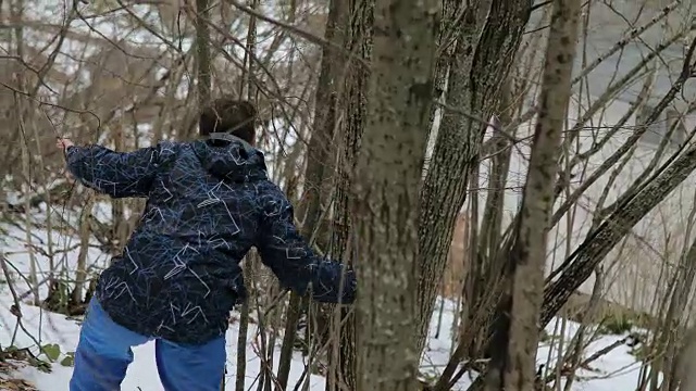 森林里的男孩。雪地里的脚步声。蓝色裤子，棕色头发。害怕和孤独视频素材