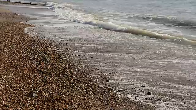 海浪拍打着布满砾石的海滩视频下载