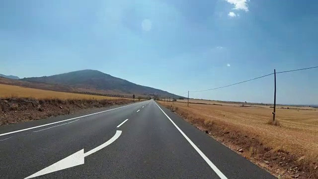 在西班牙，骑摩托车的人在风景优美的沙漠和空旷的道路上。第一个人的观点视频素材