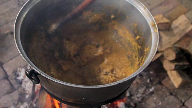 用金属锅在篝火上烹饪视频素材