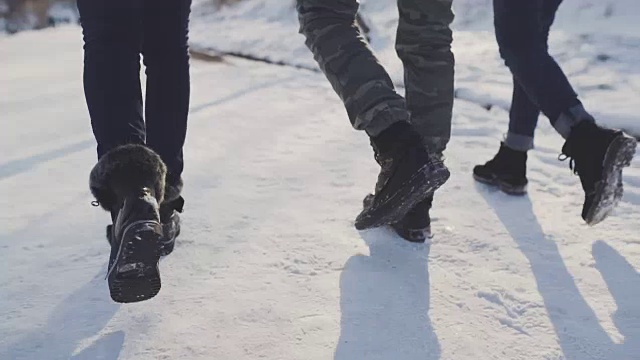 脚踩着履带鞋在雪地里行走。朋友们走在雪地上视频素材