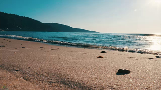 日落时分，海浪轻轻拍打着宁静的沙滩。4 k缓慢视频下载