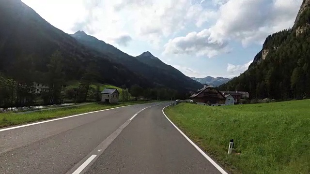 奥地利，骑摩托车的人在风景优美的山路上。第一人称视角视频素材