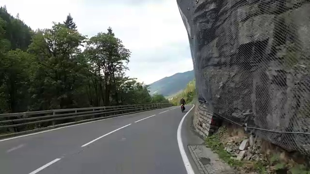 奥地利，骑摩托车的人在风景优美的山路上。第一人称视角视频素材