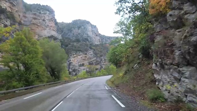 在法国，骑摩托车的人在风景山岩路上行驶。多雨的天气。第一个人的观点视频素材