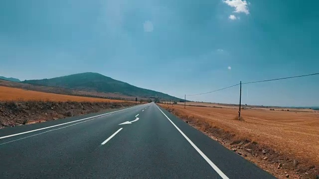 在西班牙，骑摩托车的人在风景优美的沙漠和空旷的道路上。第一个人的观点视频素材