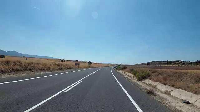 在西班牙，骑摩托车的人在风景优美的沙漠和空旷的道路上。第一个人的观点视频素材