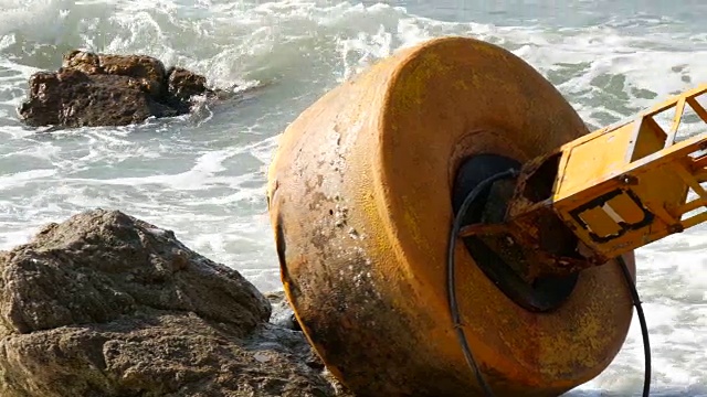 湛蓝的海岸上的黄色大浮标。海浪拍打着浮标视频素材