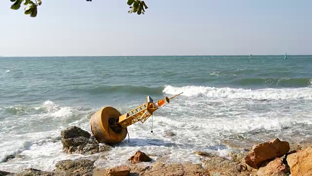 湛蓝的海岸上的黄色大浮标。海浪拍打着浮标视频素材