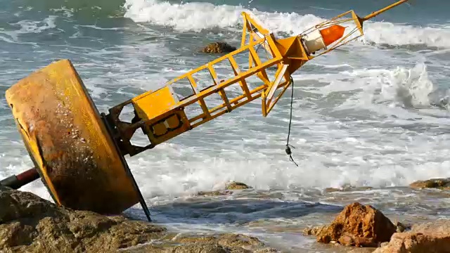 湛蓝的海岸上的黄色大浮标。海浪拍打着浮标视频素材