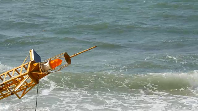 湛蓝的海岸上的黄色大浮标。海浪拍打着浮标视频素材