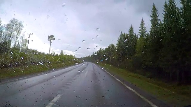 从雨中看汽车在潮湿的道路上行驶。在挪威的路上驾驶汽车视频素材