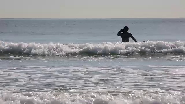 女冲浪者等待着在海洋中乘风破浪视频素材