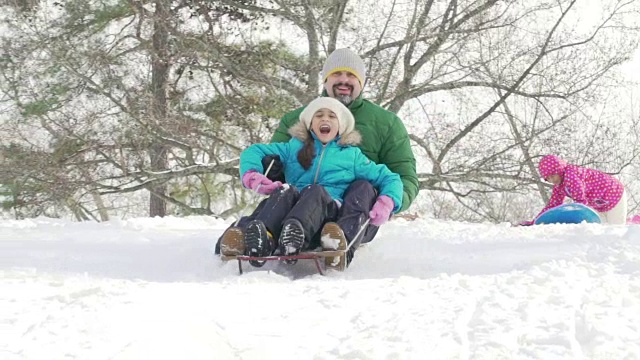 父亲和孩子们一起滑雪橇视频素材