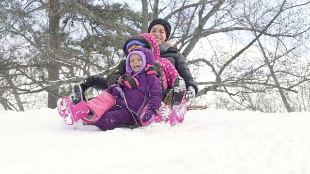 母亲和孩子们在雪中拉雪橇视频素材