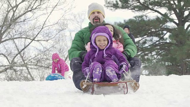 父亲和孩子们在雪中拉雪橇视频素材