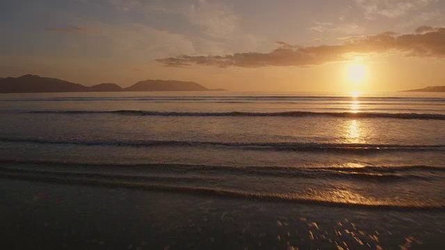 空中的海浪冲向海滩海岸在日落视频素材