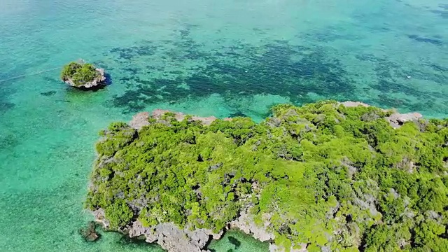 鸟瞰美丽的热带岛屿海滩，清澈湛蓝的珊瑚礁海水视频素材