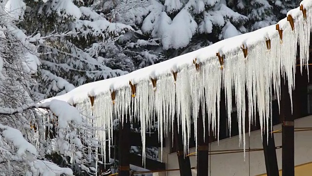 积雪覆盖的屋顶上形成了冰柱视频素材