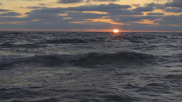 美丽的日落在海滩上，惊人的颜色，光束透过云景在海景。海上日落。日出在海滩。日落海滩。在海上日落。海上日出。慢动作视频素材