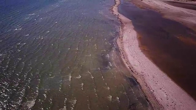 日落时靠近海边的浅水区。镜头。鸟瞰图。沙岛俯视图视频下载