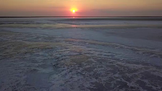 日落时分，一架无人机在乌克兰亚速海广阔的盐滩上飞过视频下载