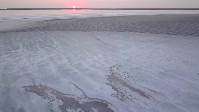 日落时分，一架无人机在乌克兰亚速海广阔的盐滩上飞过视频素材