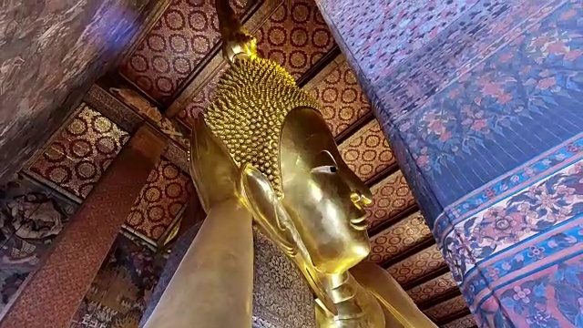 卧佛金像的脸在Wat Phra Chetupon Vimolmangklararm(卧佛)寺庙在泰国视频素材